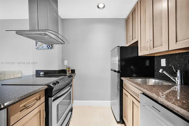 a kitchen with stainless steel appliances granite countertop a sink a stove and a microwave