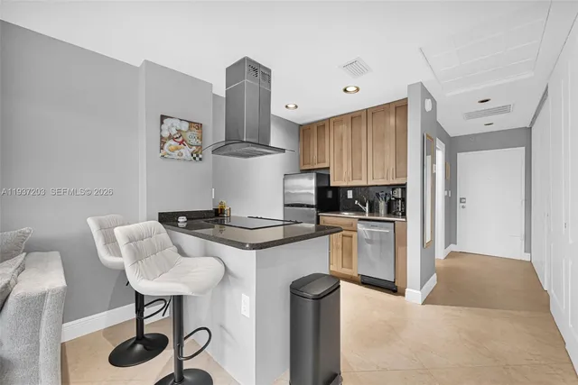 a kitchen with stainless steel appliances granite countertop a sink a stove and a refrigerator