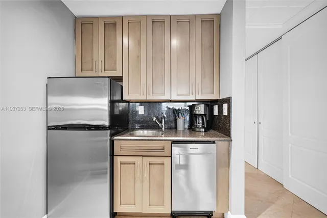 a kitchen with stainless steel appliances granite countertop a refrigerator and a stove