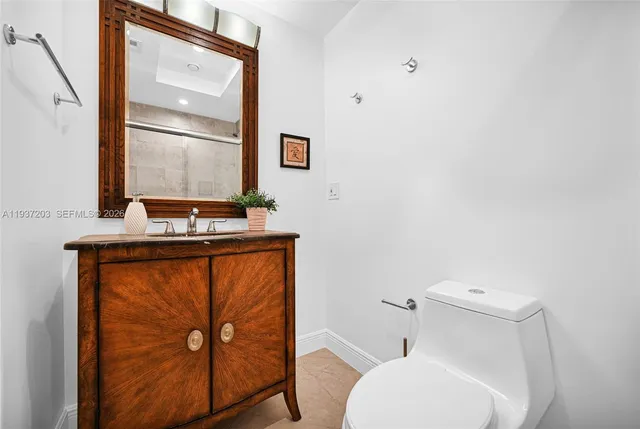 a bathroom with a toilet a sink and mirror