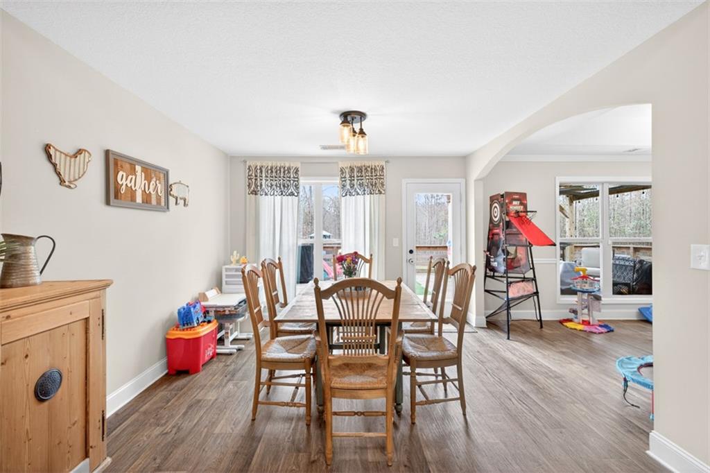 225 Tyler Way Jefferson, GA 30549 - Photo 16 of 43 a dining room with furniture wooden floor carpet and a chandelier