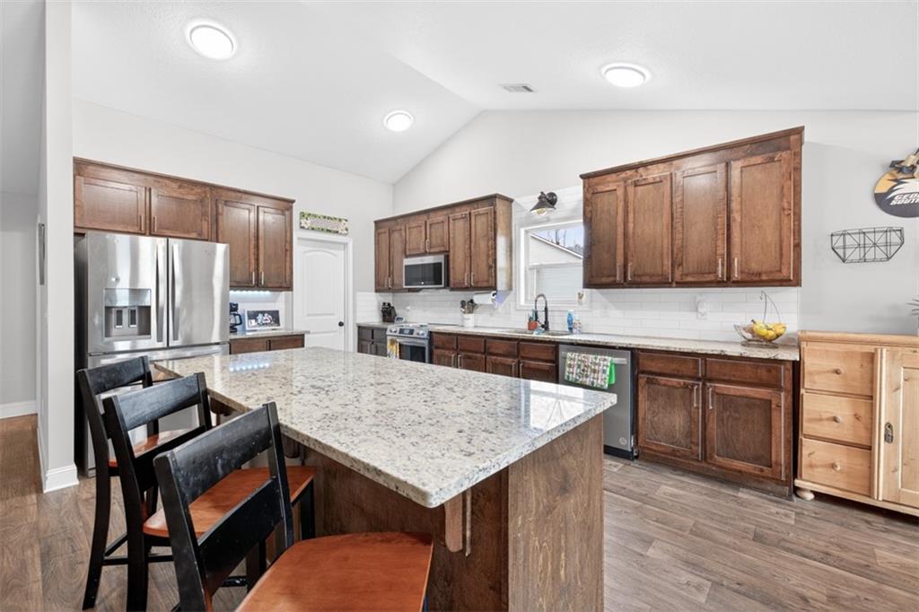 225 Tyler Way Jefferson, GA 30549 - Photo 19 of 43 a kitchen with granite countertop kitchen island wooden cabinets and stainless steel appliances