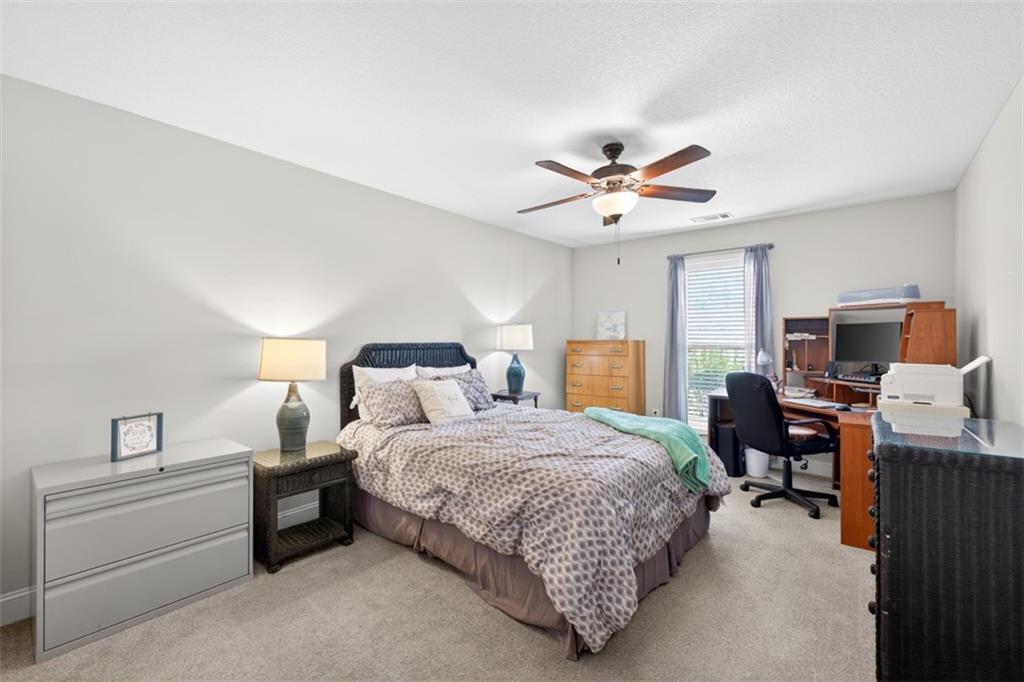 225 Tyler Way Jefferson, GA 30549 - Photo 23 of 43 a bedroom with a bed and a chandelier