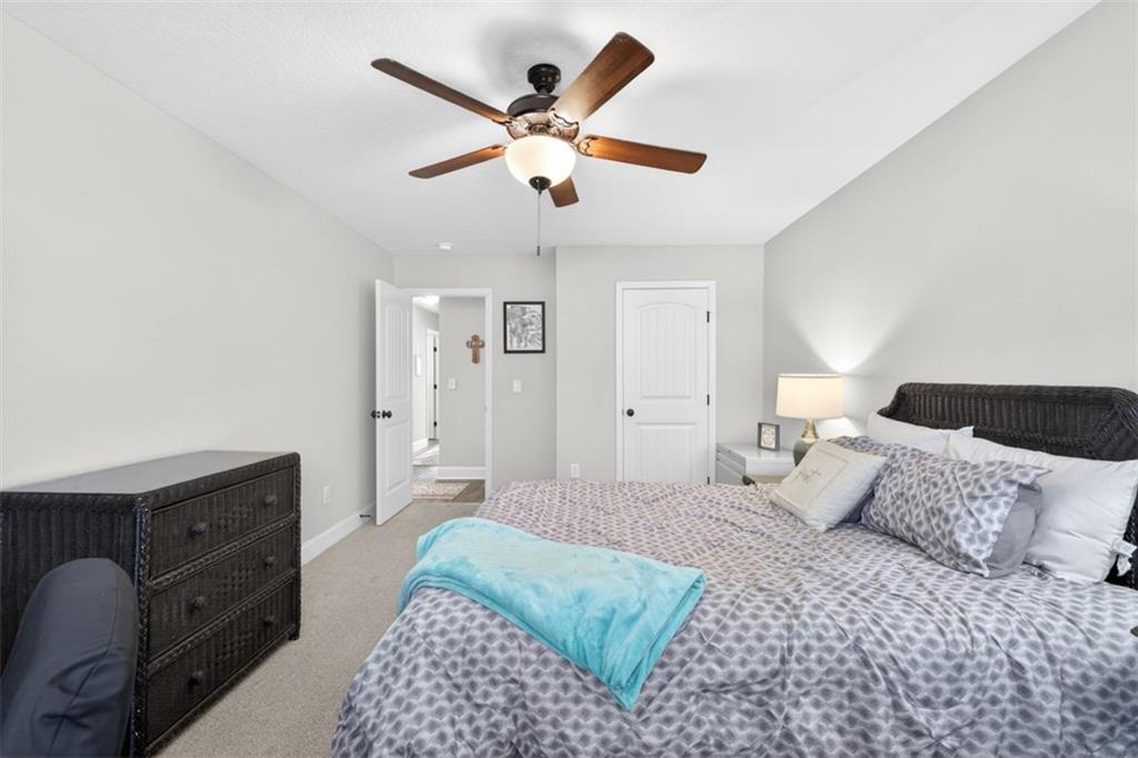 225 Tyler Way Jefferson, GA 30549 - Photo 24 of 43 a bedroom with a large bed and a ceiling fan