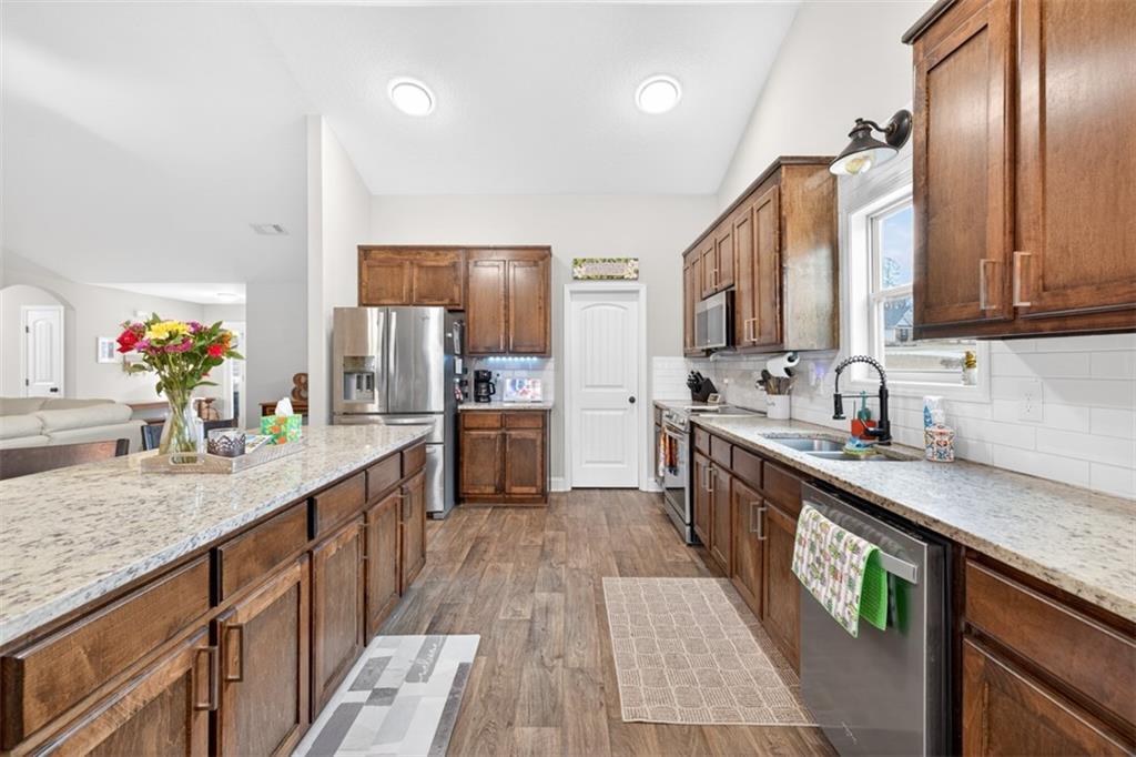 225 Tyler Way Jefferson, GA 30549 - Photo 8 of 43 a kitchen with stainless steel appliances granite countertop a sink stove and refrigerator