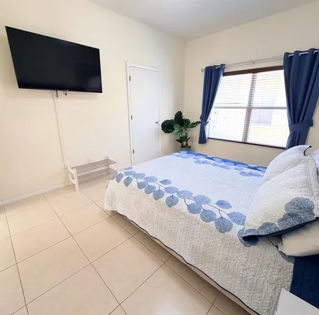 a bedroom with a bed and a flat screen tv