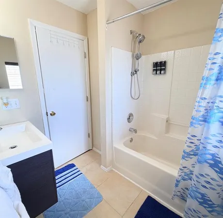 a bathroom with a tub shower vanity and a sink