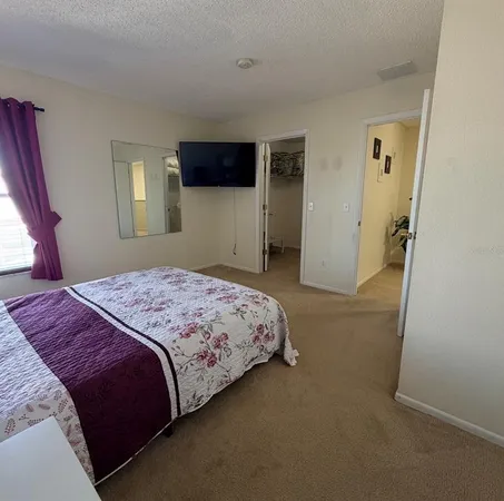 a bedroom with a bed and a flat screen tv