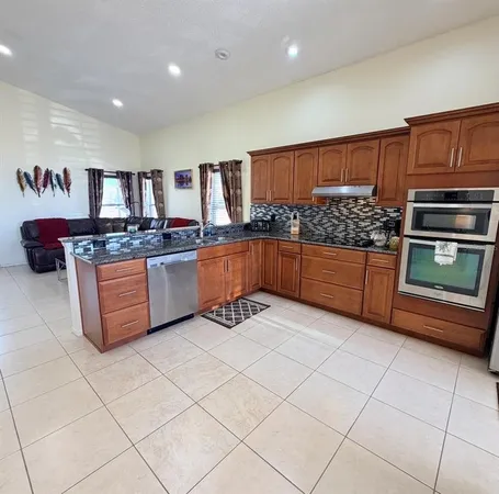 a kitchen with stainless steel appliances granite countertop a stove and a sink