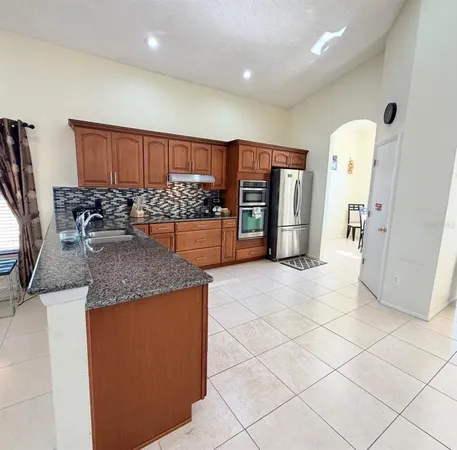 a kitchen with stainless steel appliances granite countertop a refrigerator and a stove