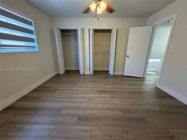 an empty room with wooden floor and closet