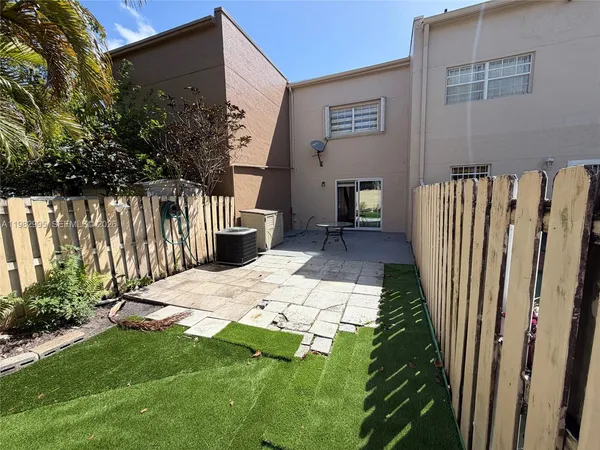 a backyard of a house with table and chairs