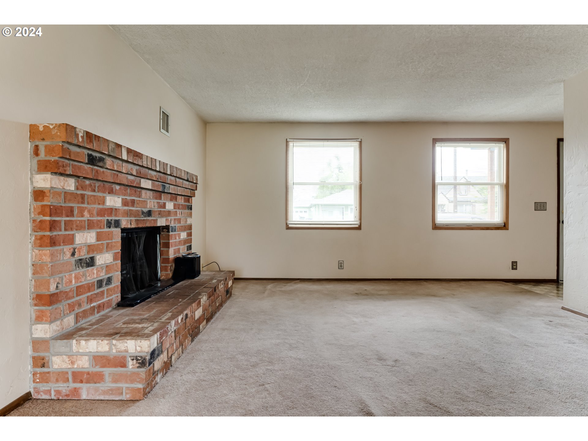 1038 5th Street Springfield, OR 97477 - Photo 4 of 26 a view of an empty room with a fireplace and a window
