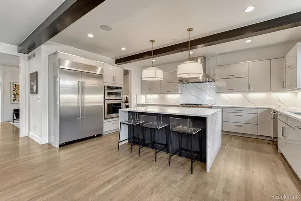 a kitchen with stainless steel appliances granite countertop a sink a stove and a refrigerator