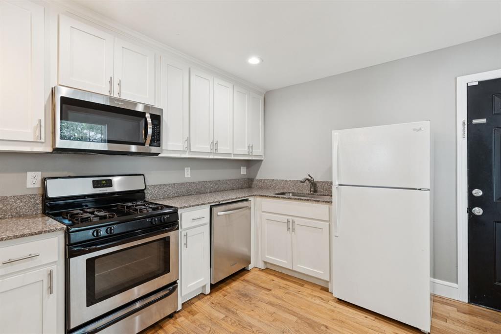3222 Inwood Road Dallas, TX 75235 - Photo 11 of 25 a kitchen with cabinets stainless steel appliances and wooden floor