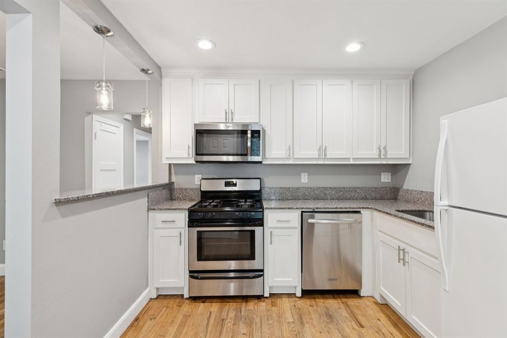 3222 Inwood Road Dallas, TX 75235 - Photo 10 of 25 a kitchen with white cabinets and stainless steel appliances