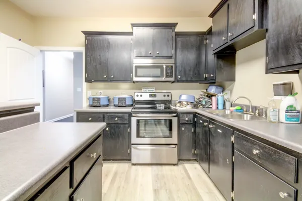 a kitchen with stainless steel appliances granite countertop a stove a sink and a refrigerator