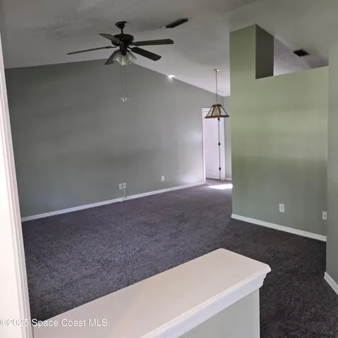 a view of a livingroom with a ceiling fan and hardwood floor