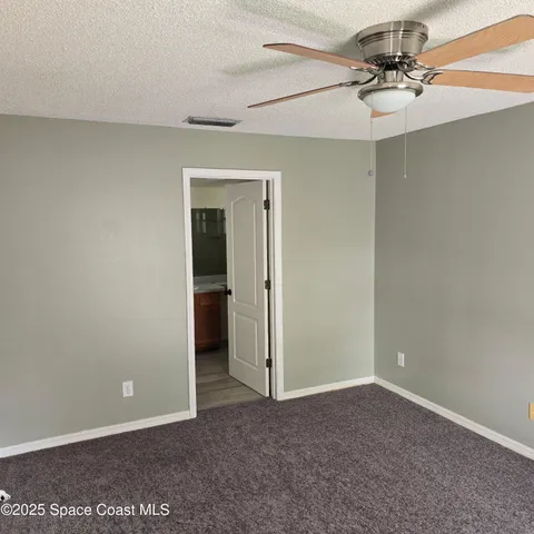 an empty room with a ceiling fan and a window