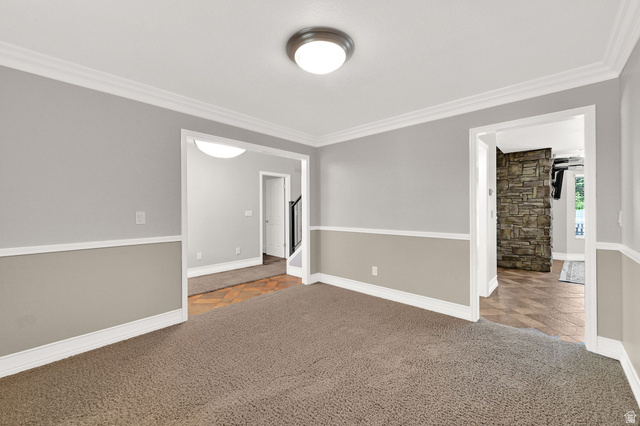4792 Glasmann Way South Ogden, UT 84403 - Photo 30 of 70 Neutral toned interior space featuring carpet flooring and crown molding with views into the entrance way and kitchen area