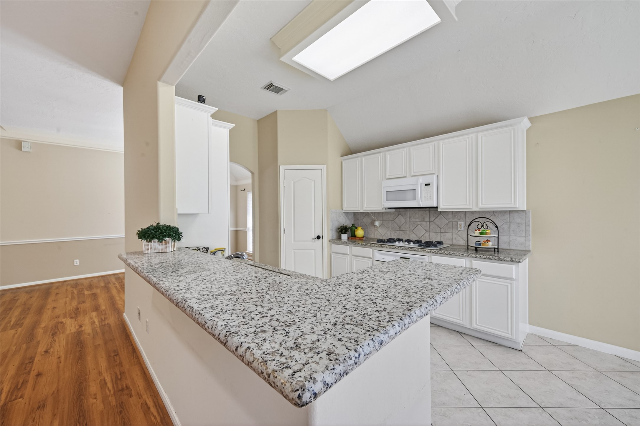 23211 Goldensong Court Spring, TX 77373 - Photo 19 of 50 The kitchen is bright with beautiful Granite, white cabinets and beautiful back splash.
