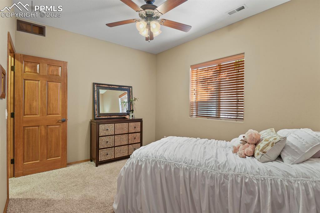 2563 Integrity Court Colorado Springs, CO 80918 - Photo 34 of 49 a bedroom with a bed and a chandelier