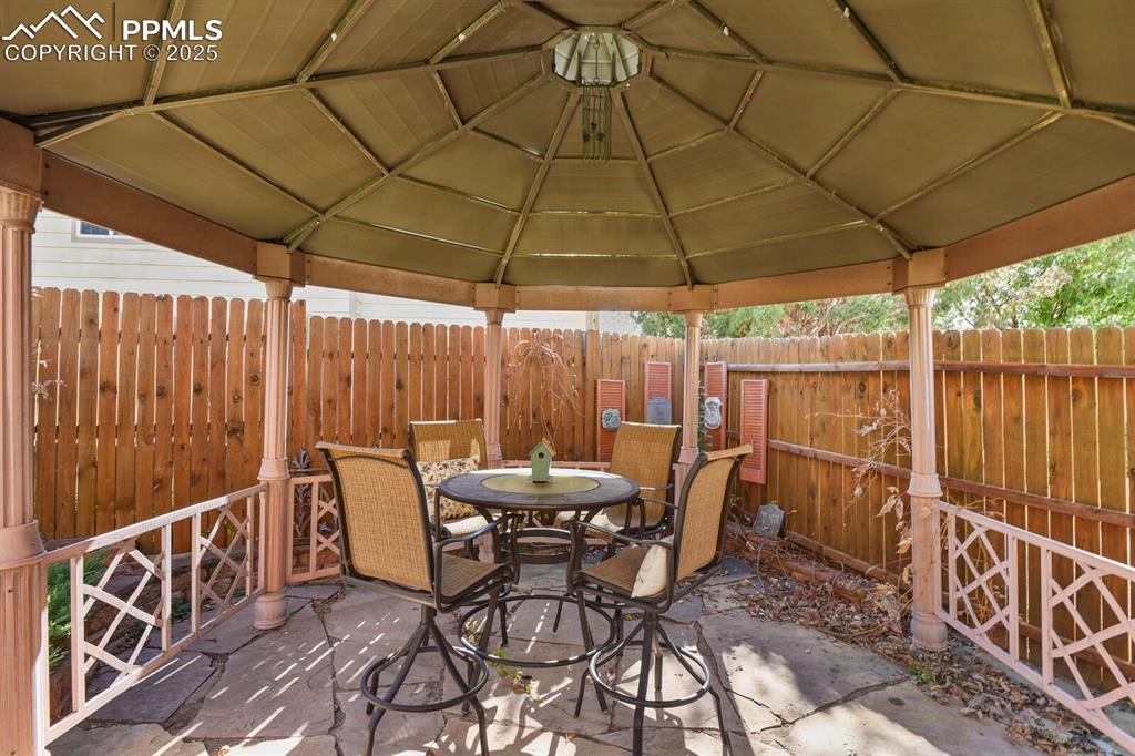 2563 Integrity Court Colorado Springs, CO 80918 - Photo 40 of 49 a patio with wooden floor a yard a table and chairs