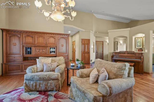a living room with furniture or chandelier and a wooden floor
