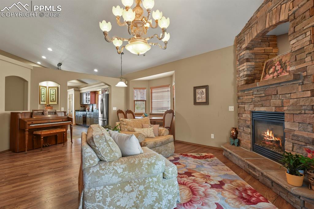 2563 Integrity Court Colorado Springs, CO 80918 - Photo 8 of 49 a living room with furniture a chandelier and a fireplace