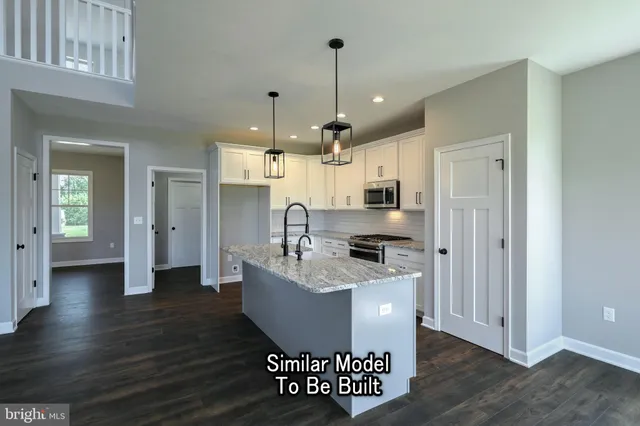 a kitchen with stainless steel appliances granite countertop a sink a stove and a refrigerator