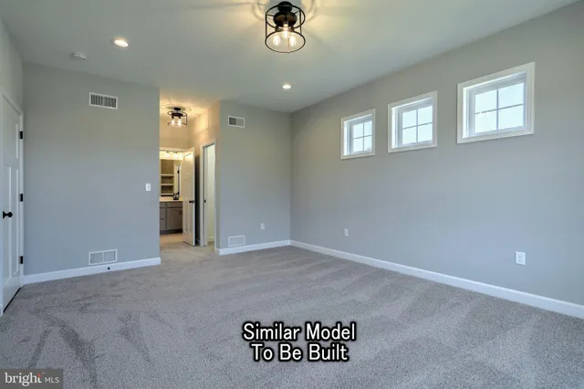 an empty room with windows fireplace and wooden floor