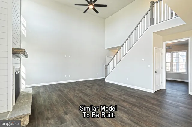 an empty room with windows and ceiling fan