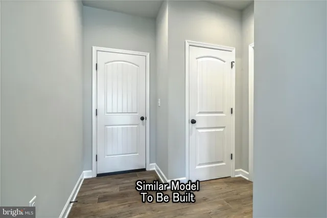 an empty room with wooden floor ceiling fan and windows