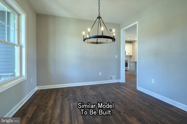 a view of an empty room with wooden floor fireplace and a window
