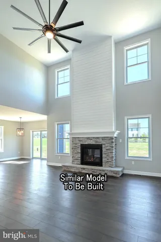 an empty room with wooden floor fireplace and windows