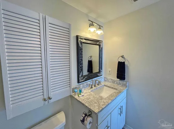 a bathroom with a granite countertop sink and a mirror
