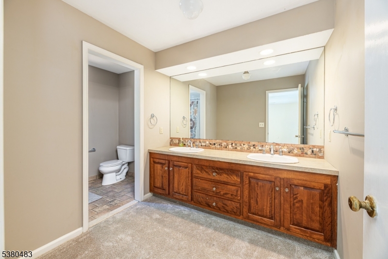 11 Indian Hollow Road Mendham, NJ 07945 - Photo 14 of 26 a spacious bathroom with a double vanity sink toilet mirror and bathtub