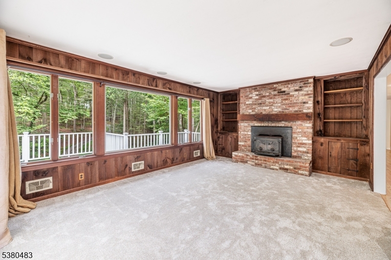 11 Indian Hollow Road Mendham, NJ 07945 - Photo 7 of 26 a view of an empty room with a fireplace and a window