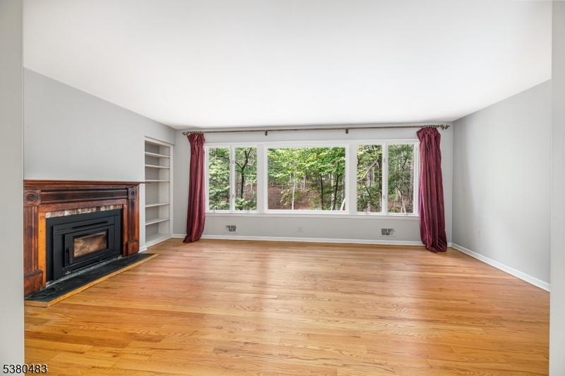 11 Indian Hollow Road Mendham, NJ 07945 - Photo 9 of 26 a view of empty room with wooden floor and fireplace