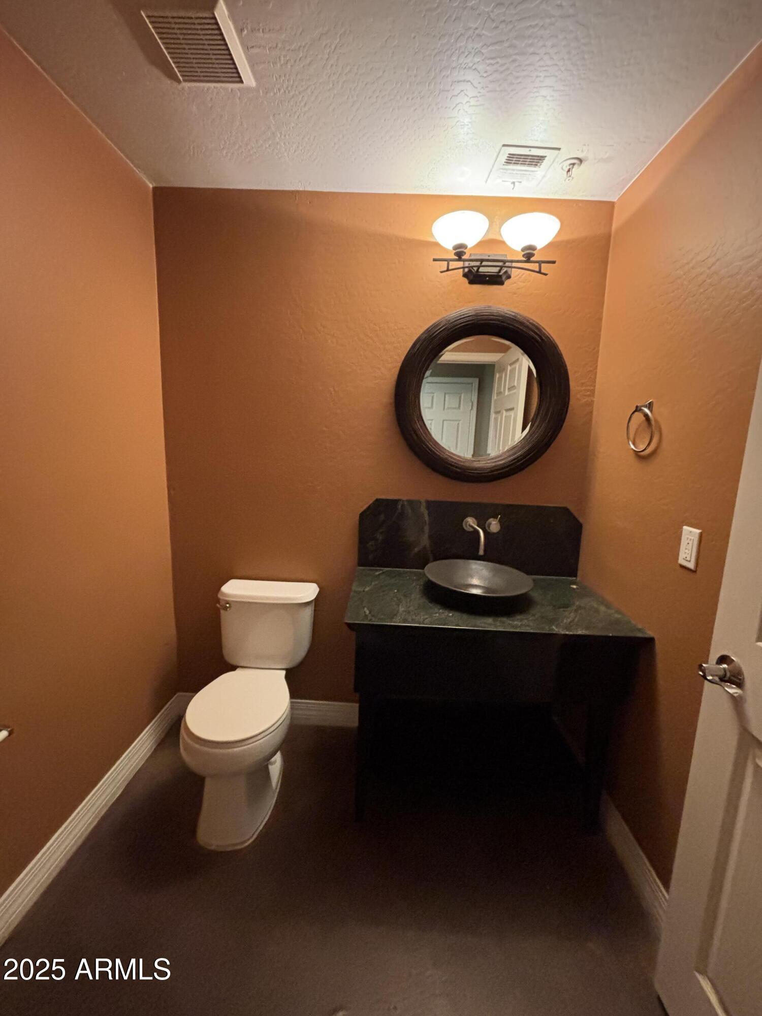 615 East Portland Street, Unit 113 Phoenix, AZ 85004 - Photo 12 of 28 a bathroom with a toilet a sink and mirror