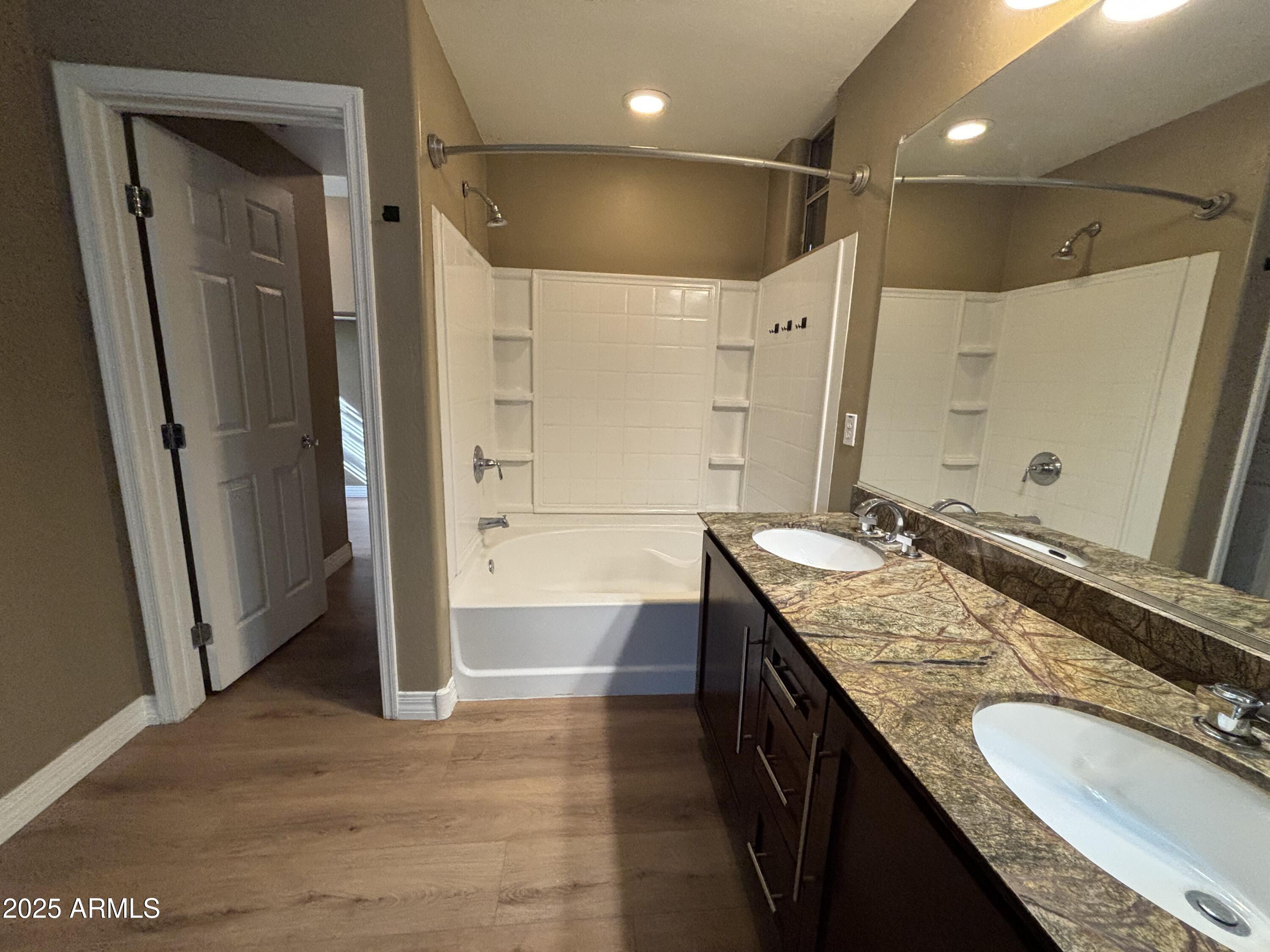 615 East Portland Street, Unit 113 Phoenix, AZ 85004 - Photo 17 of 28 a bathroom with a granite countertop sink a mirror and a shower