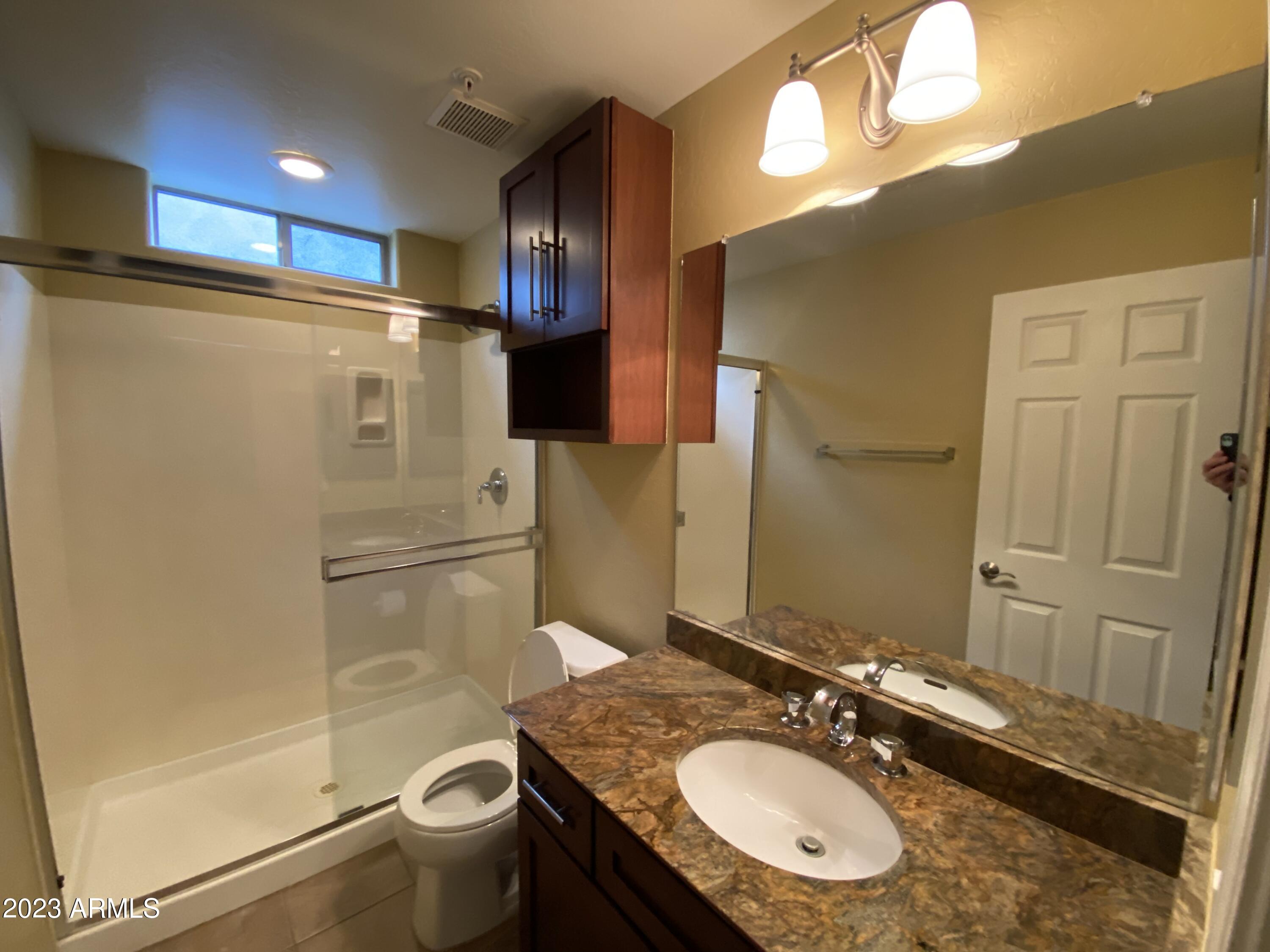 615 East Portland Street, Unit 113 Phoenix, AZ 85004 - Photo 21 of 28 a bathroom with a granite countertop sink toilet and shower