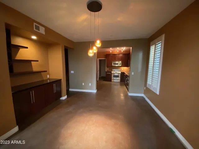 a view of an empty room with furniture and a window