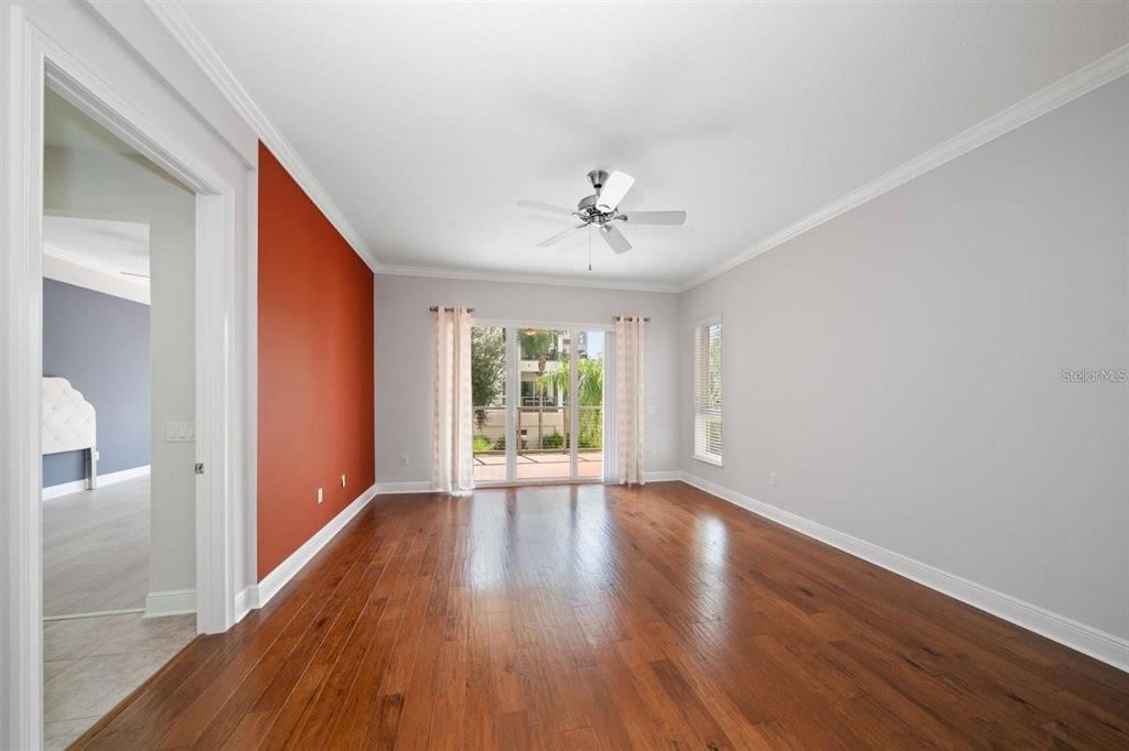 1030 Bellasol Way, Unit 201 Apollo Beach, FL 33572 - Photo 11 of 36 a view of an empty room with wooden floor and a window