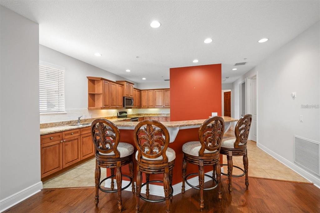 1030 Bellasol Way, Unit 201 Apollo Beach, FL 33572 - Photo 12 of 36 a view of a dining room with furniture and wooden floor
