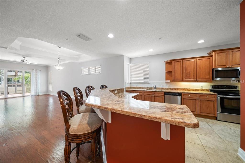 1030 Bellasol Way, Unit 201 Apollo Beach, FL 33572 - Photo 15 of 36 a kitchen with a table chairs microwave and cabinets