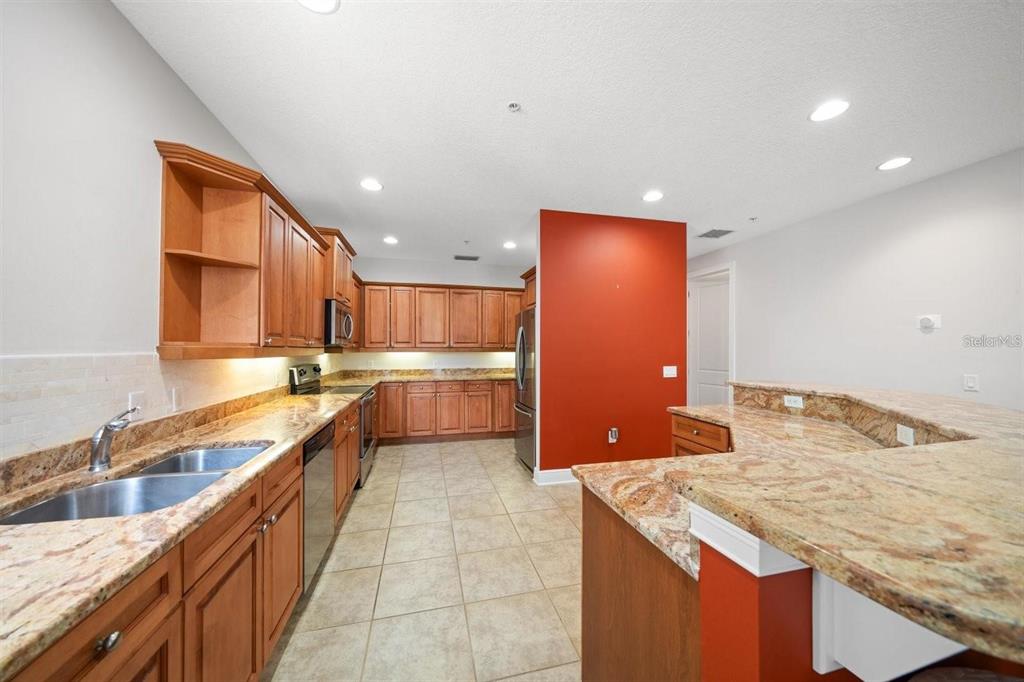 1030 Bellasol Way, Unit 201 Apollo Beach, FL 33572 - Photo 6 of 36 a kitchen with stainless steel appliances granite countertop a sink counter space and a stove