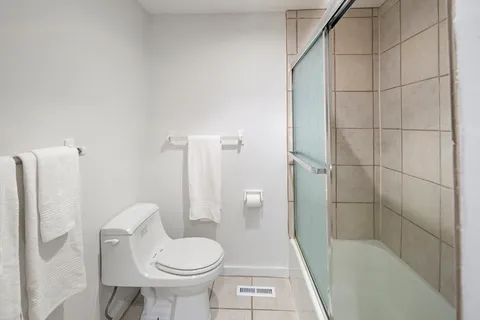 a bathroom with a toilet and a shower