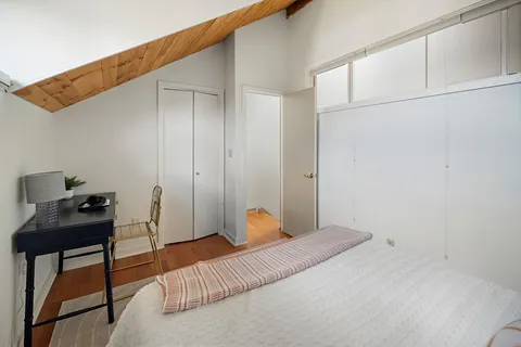 a bedroom with a bed and a desk