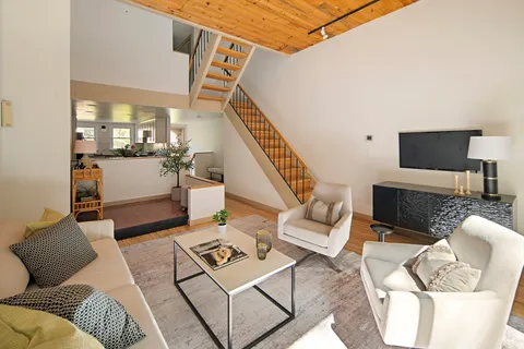 a living room with furniture a rug and white walls